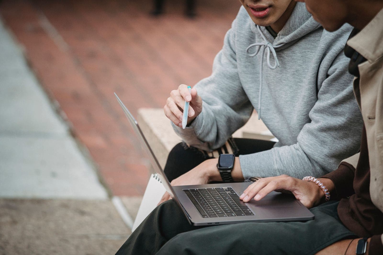 Two people sitting together and using a laptop